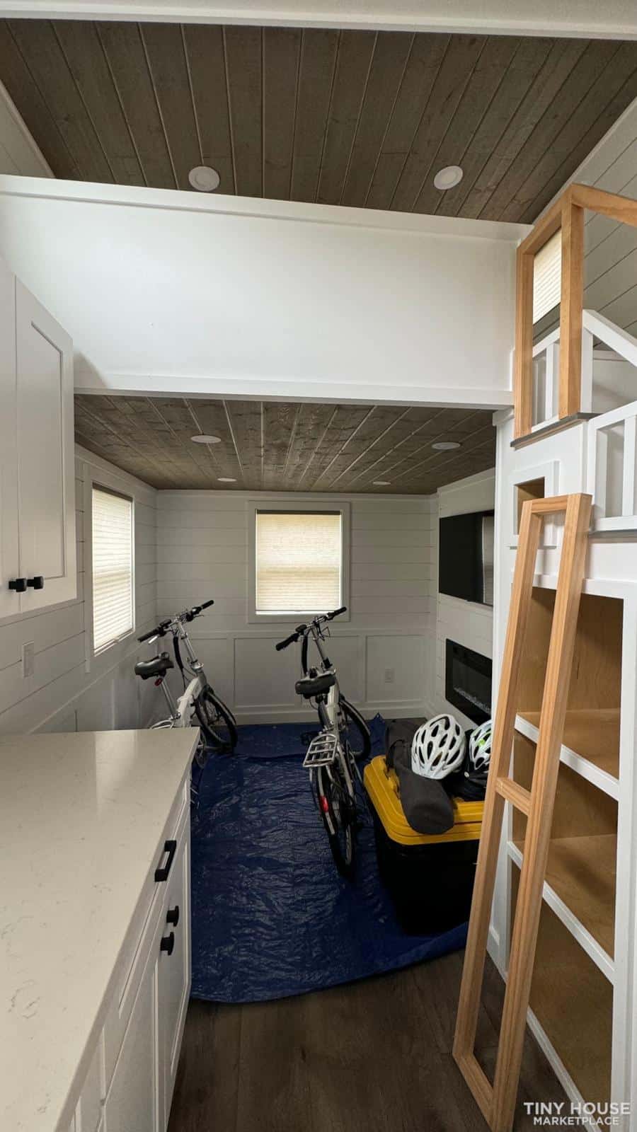 Cozy tiny house interior with bicycles, storage, and modern design elements.