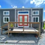 Tiny house on wheels with modern design and red front door in Georgia.
