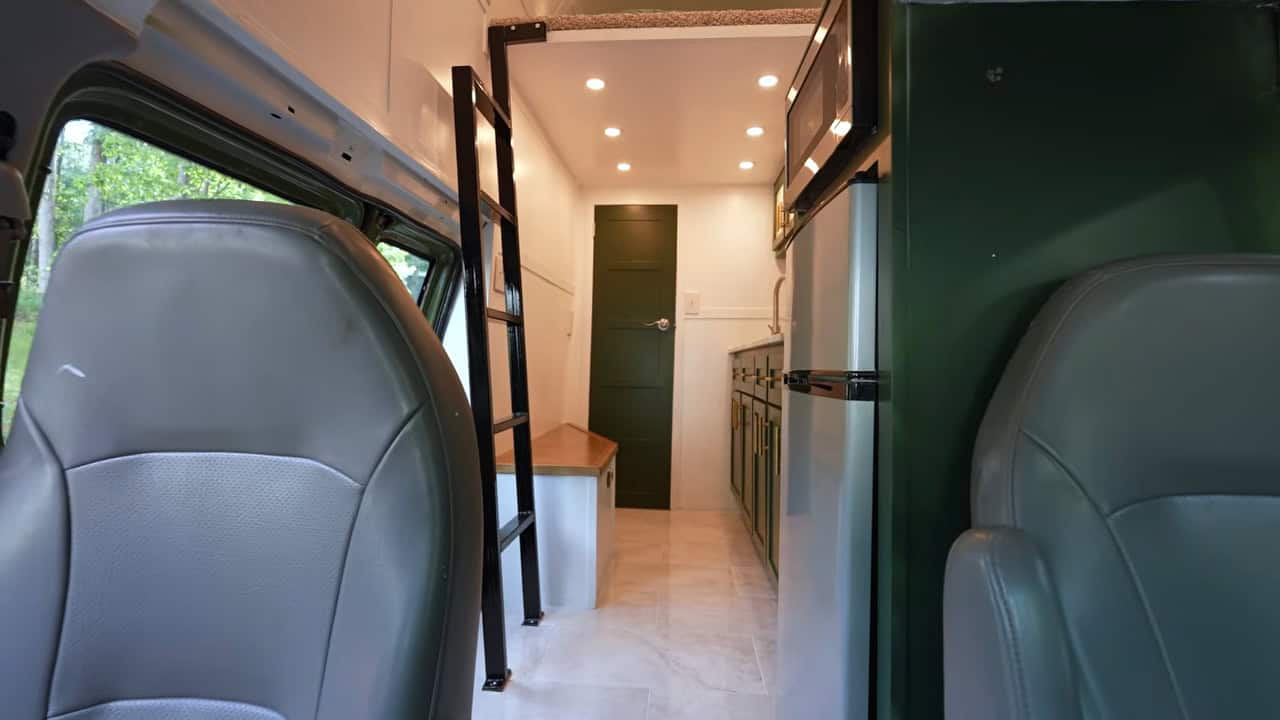 Finished van interior with ladder to the loft, galley kitchen and refrigerator