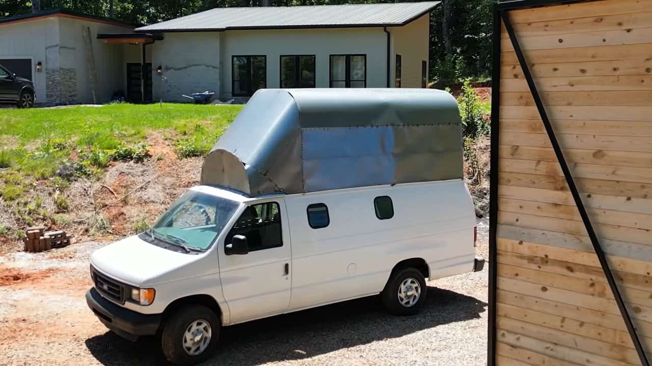 Van parked outside with the bare metal second-story shell mounted