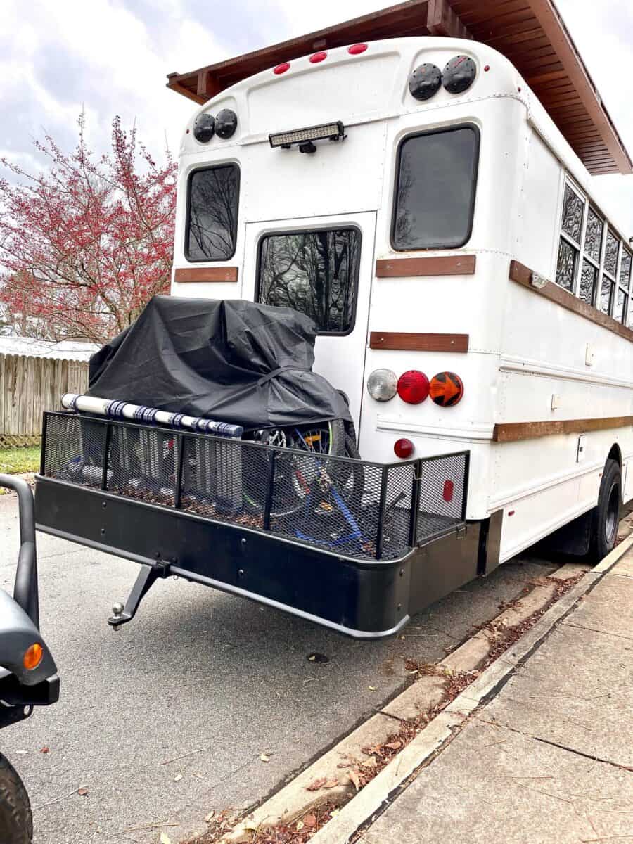 Converted skoolie bus home with outdoor bike rack, perfect for small family living.