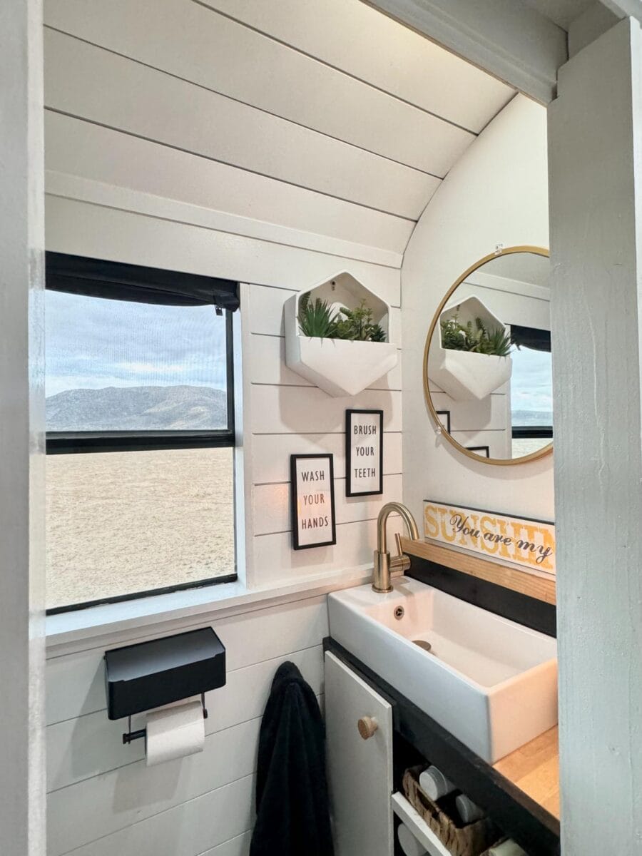 Bright tiny house bathroom with white shiplap walls and stylish decor.