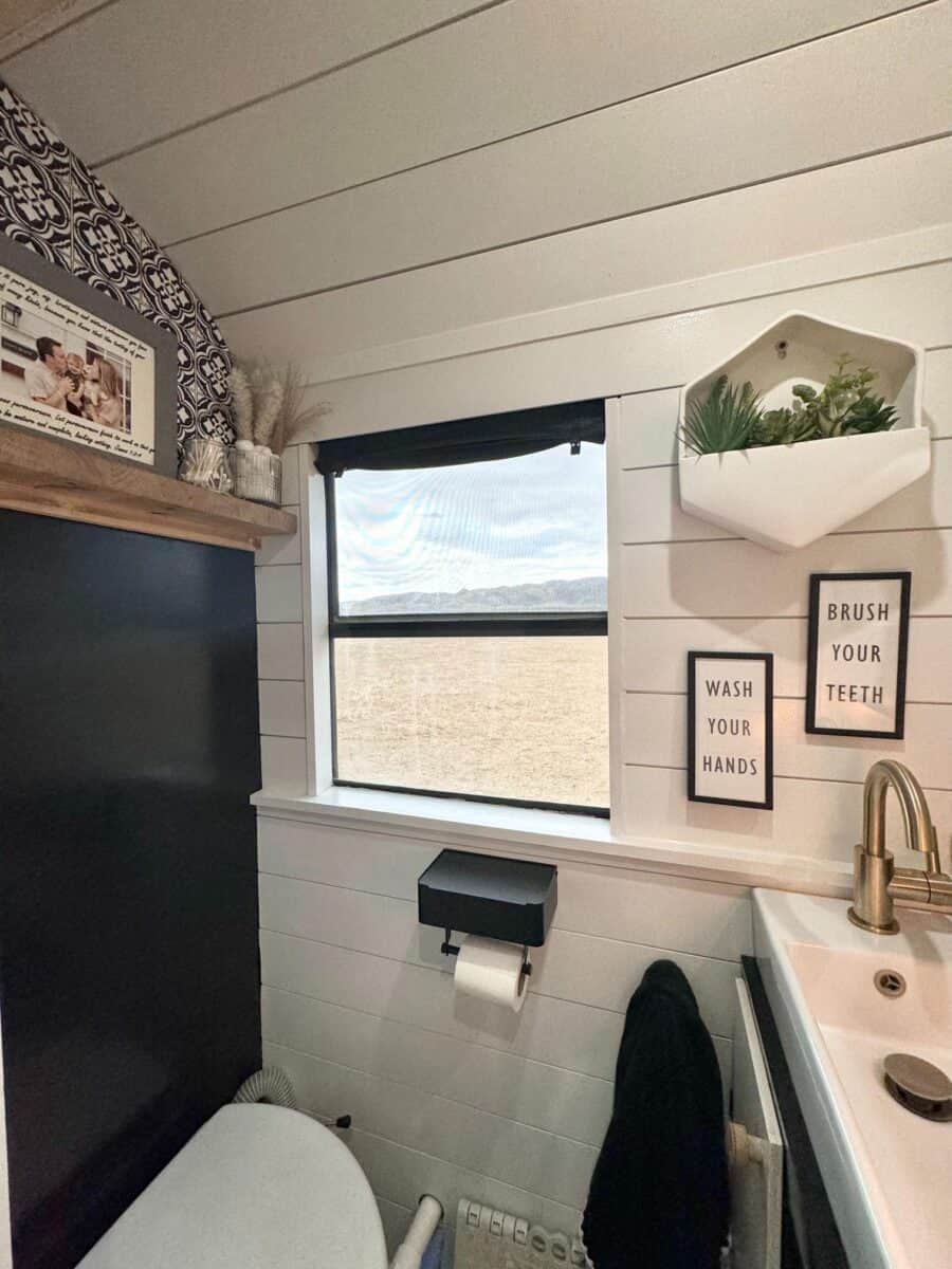 Compact bathroom with modern fixtures in a tiny house on wheels.