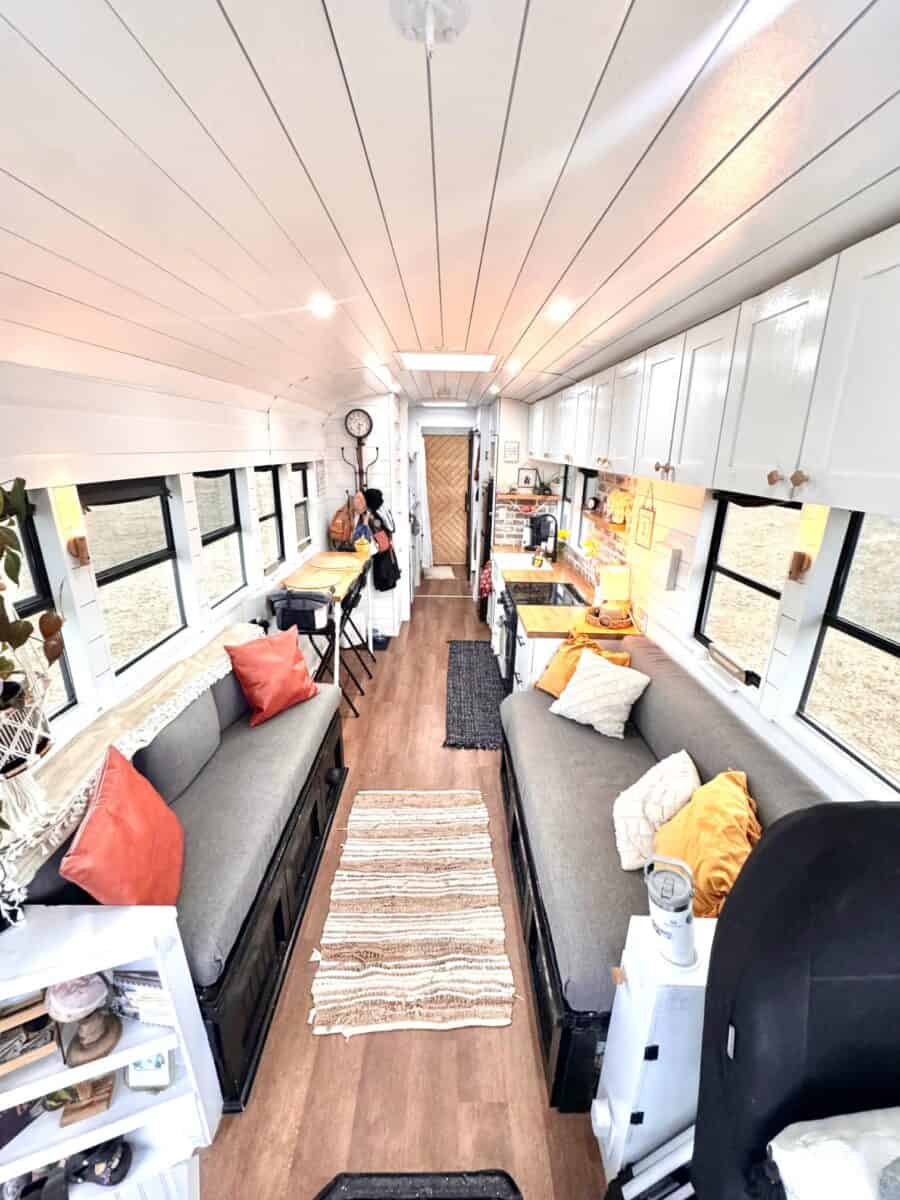 Interior view of a tiny house on wheels with comfortable seating and ample storage.