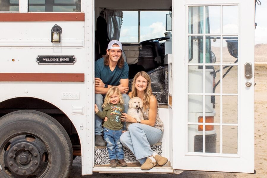 Family of three with their dog inside a stunning skoolie tiny home.