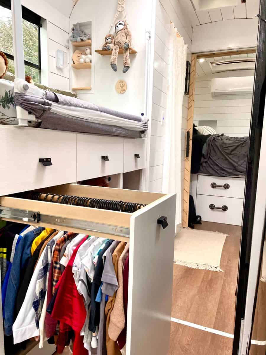 Compact closet in tiny house with organized clothing and toys.
