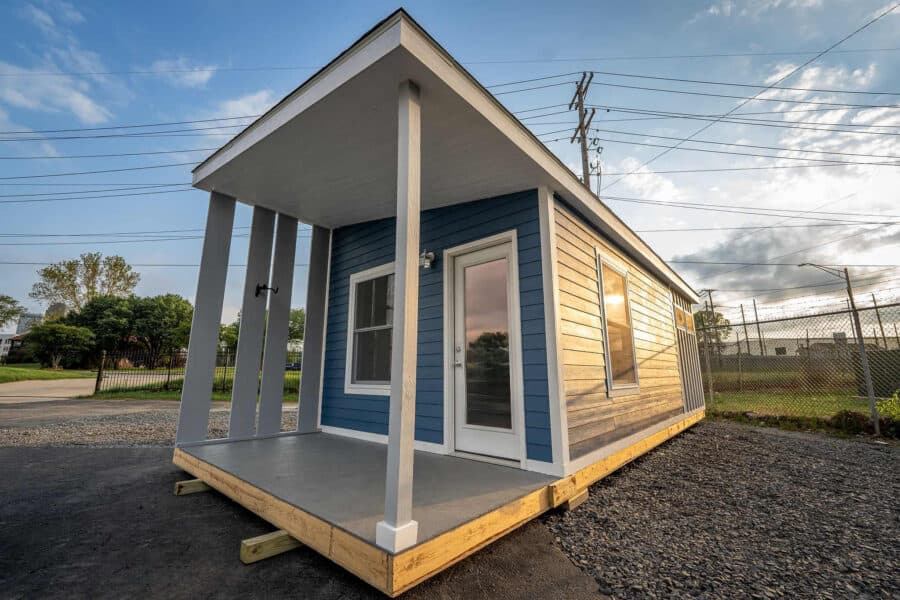 Tiny house with modern design and porch, providing affordable housing solutions in Arkansas.
