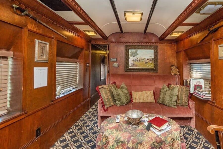 Interior of a historic Pullman train car converted into a tiny house with vintage decor.