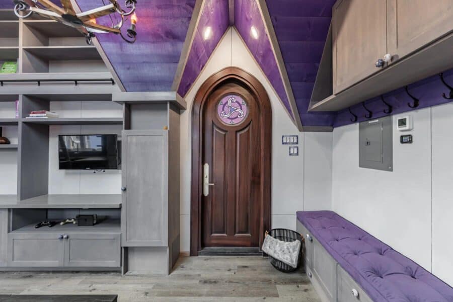 Cozy tiny house interior featuring purple accents and smart storage solutions.
