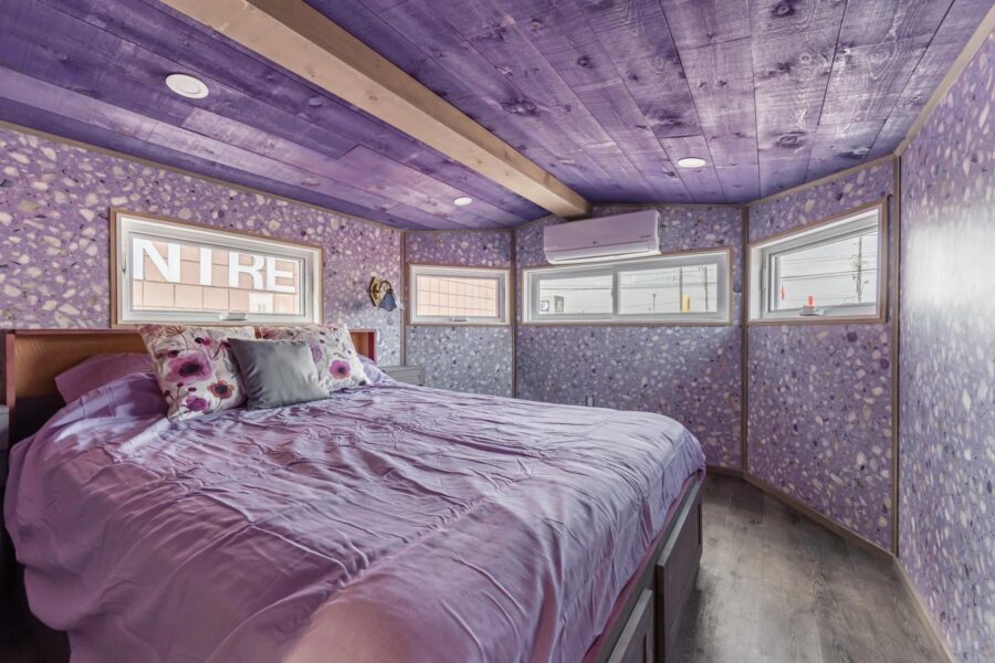 Cozy tiny house bedroom featuring purple walls and ceiling for a relaxing retreat.