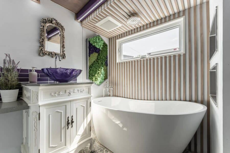 Elegant tiny bathroom featuring a freestanding bathtub and stylish decor in a small space.