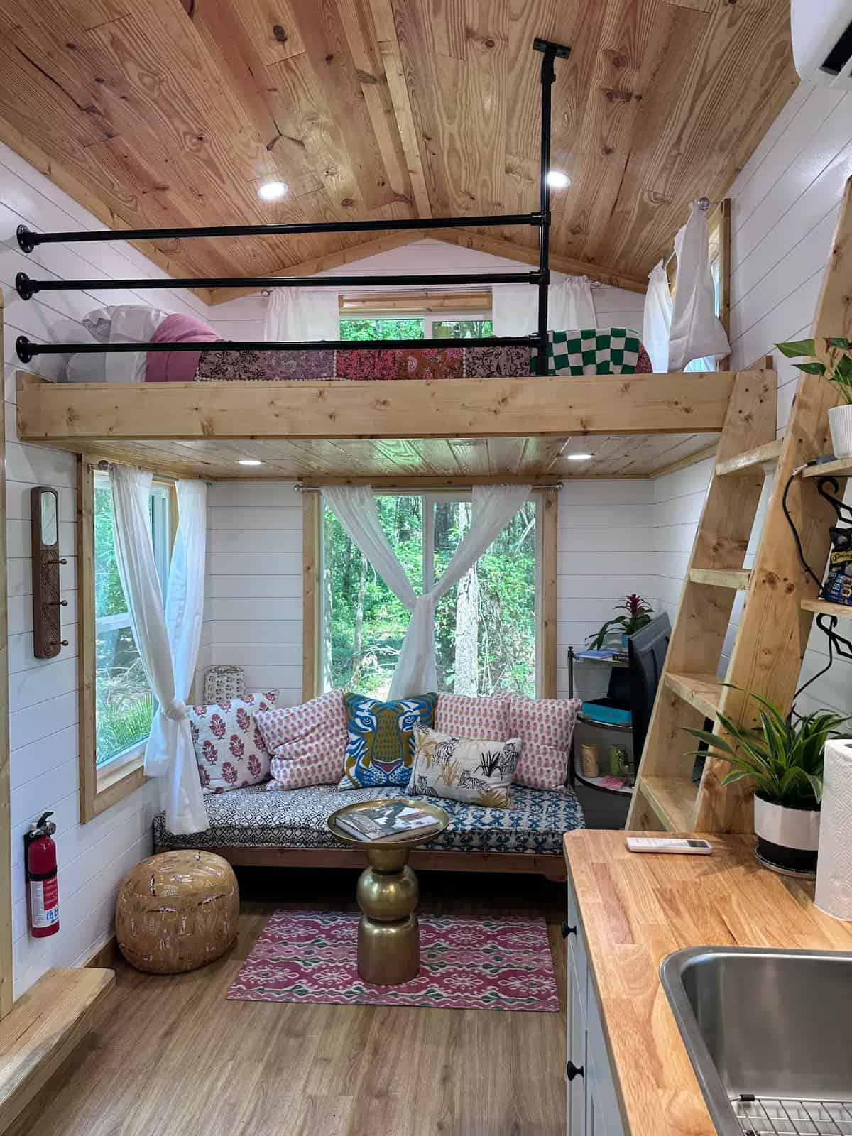 Interior of the Rasa tiny home showing one of its two sleeping lofts above the living area