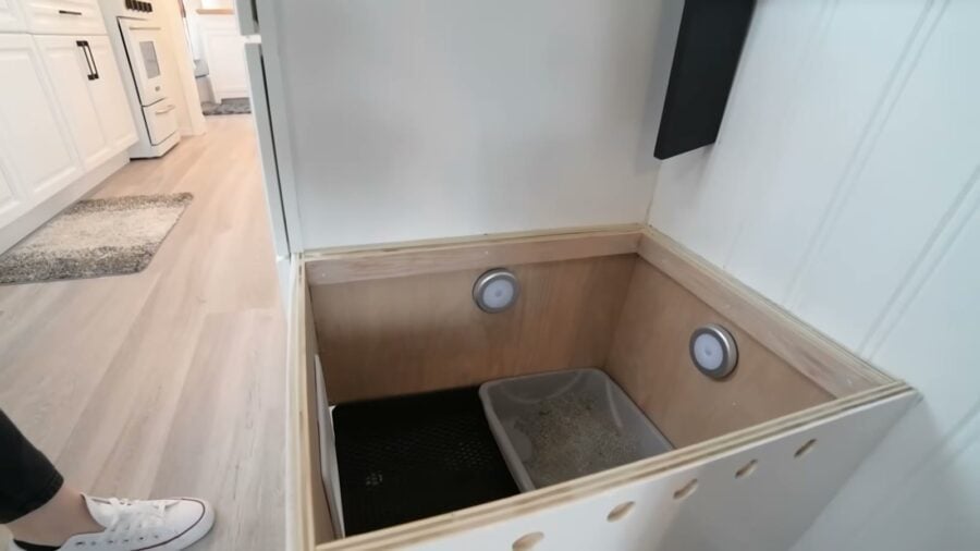 Hidden cat litter box built into the bottom step of tiny house stairs
