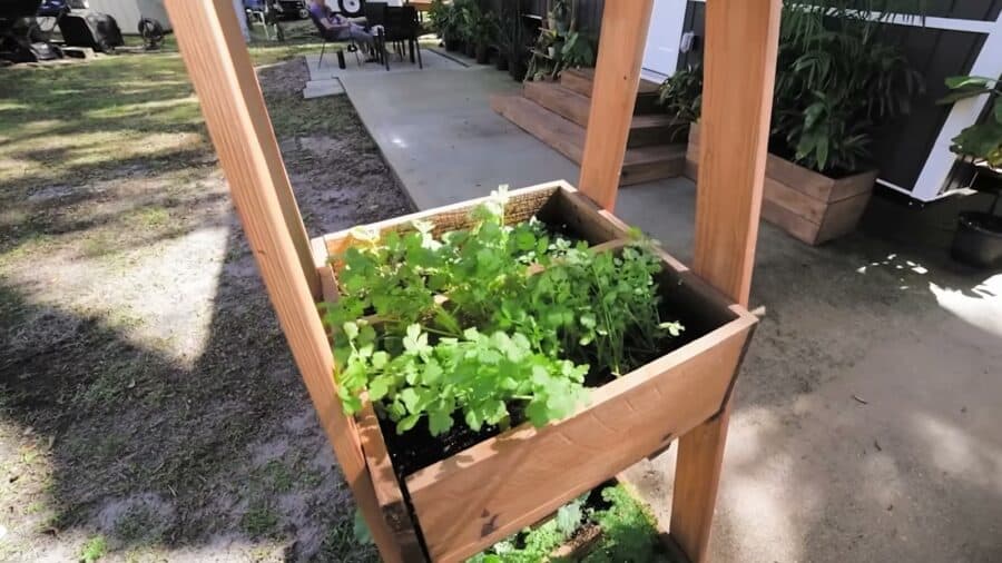 Raised herb and vegetable planter beside a tiny house
