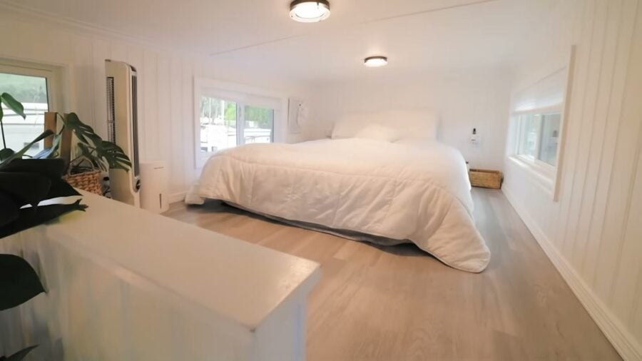 Main sleeping loft with queen bed in a tiny house on wheels