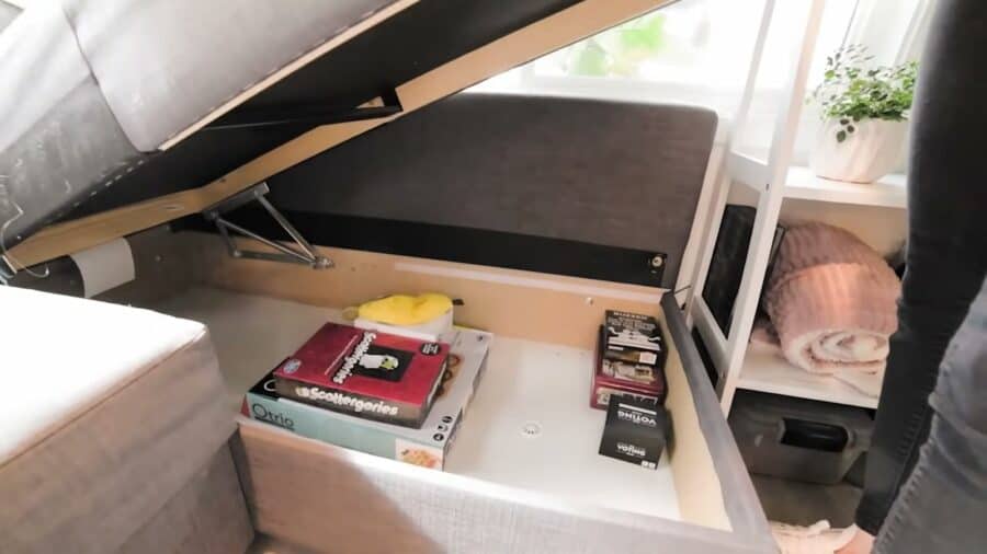 Storage compartment hidden under the sectional sofa in a tiny house