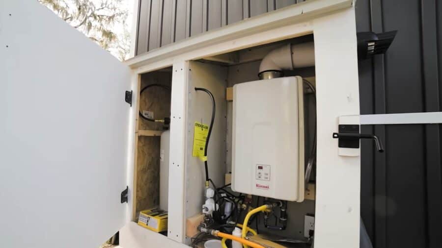 Outdoor shed housing a tankless propane water heater for a tiny house