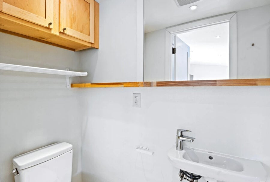 Modern tiny house bathroom with minimalist design and compact fixtures.