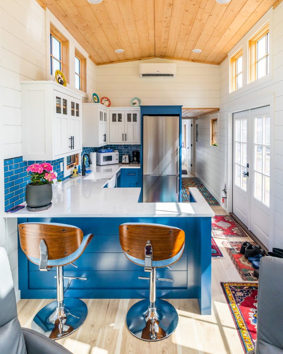 Bar seating at the blue kitchen peninsula seen from the living room