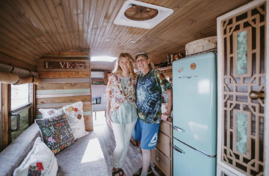 Couple enjoying retirement in their cozy skoolie tiny home interior.