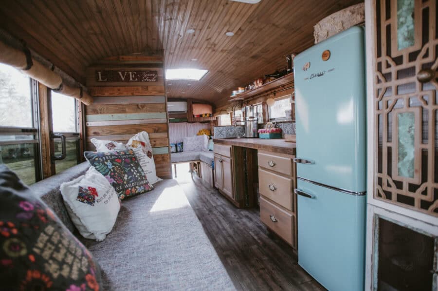 Compact tiny house interior with vintage fridge and cozy seating area.