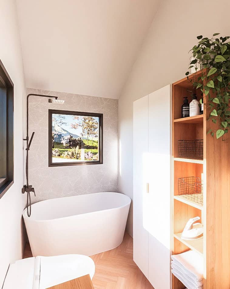 Freestanding bathtub in a cozy tiny house bathroom with natural light and minimalist decor.