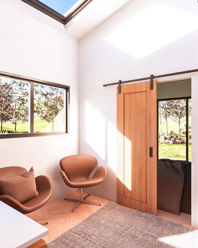 Cozy tiny house interior featuring a sliding barn door and modern seating.