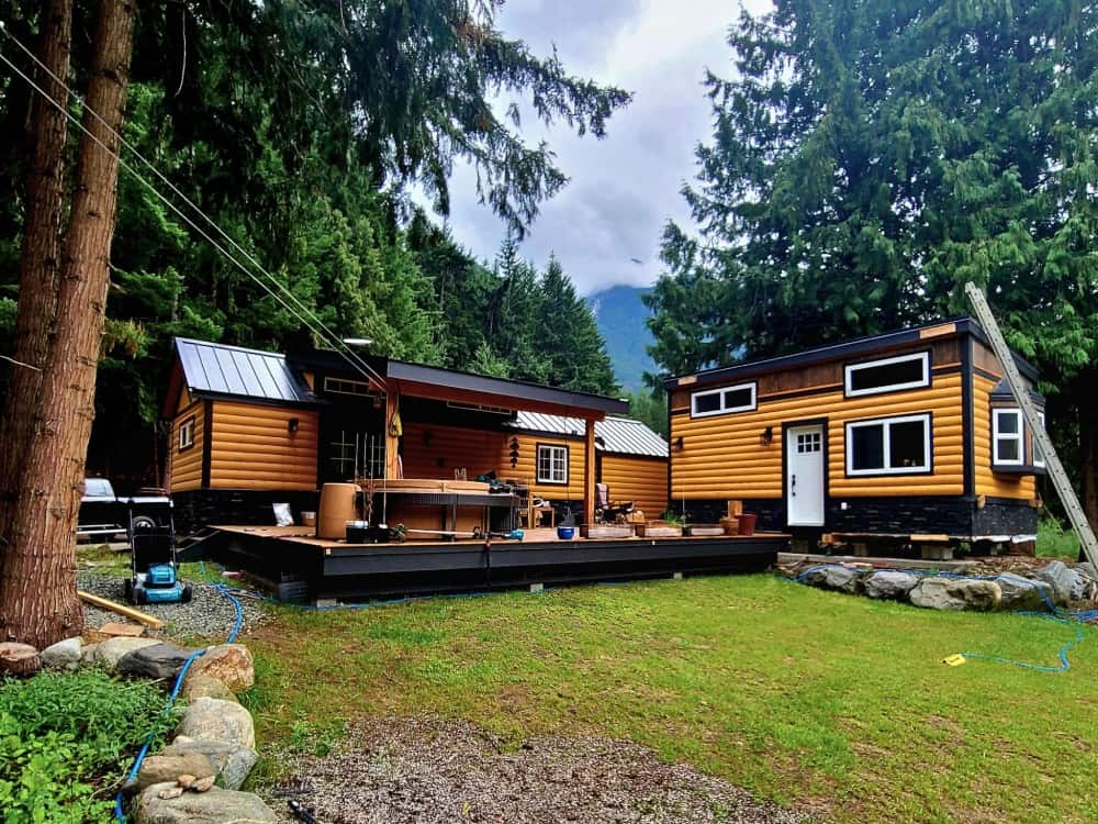 Two Black Bear community cottages set side by side on a shared wooden deck among the trees