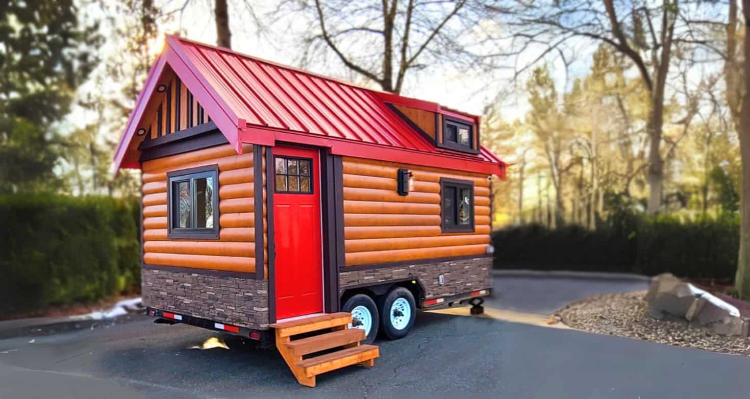 Rolling Bear Honeycomb Mobile Office, a log-cabin-style tiny house on wheels with a red metal roof, red door, stone skirting, and fold-down steps