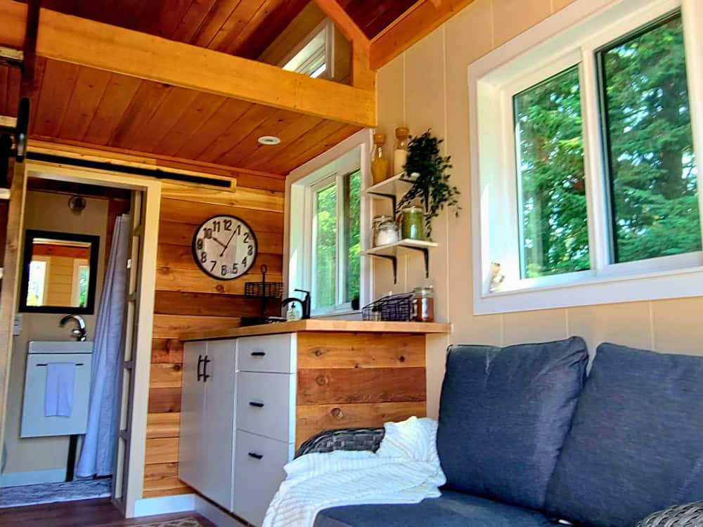 View through the barn door to the Honeycomb Office Farmhand bathroom vanity, beside the kitchenette and living area