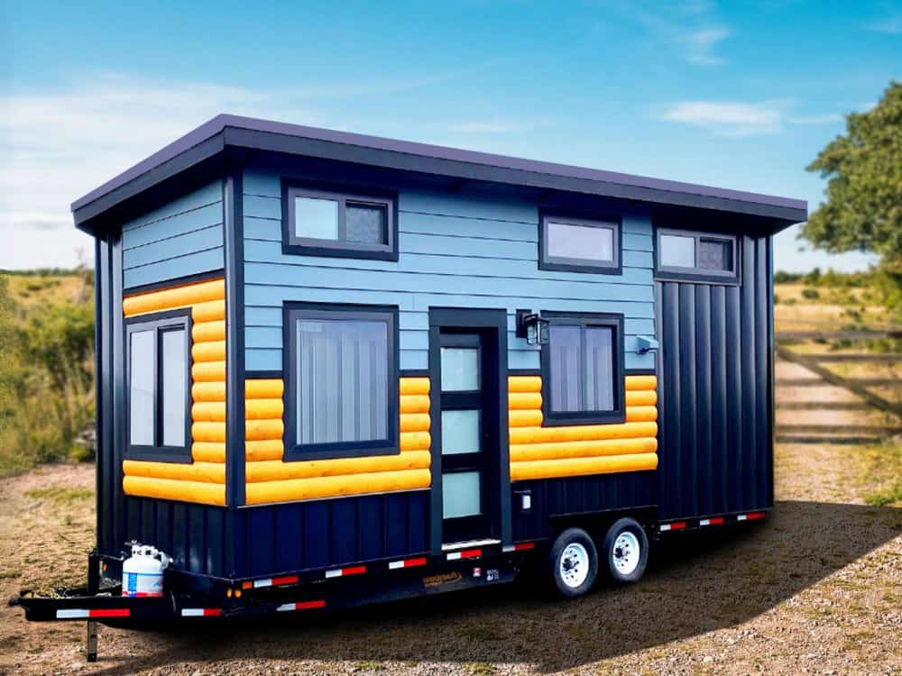 Rolling Bear Koala Bear tiny house on wheels with bold navy and grey siding, golden half-log accent panels, a flat roof, and dormer windows