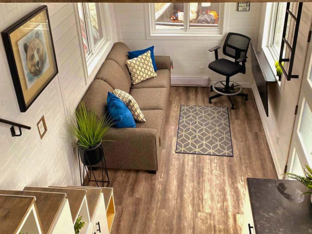 Koala Bear living room with a brown sofa, blue throw pillows, a bear painting, and a built-in desk with an ergonomic chair under a window
