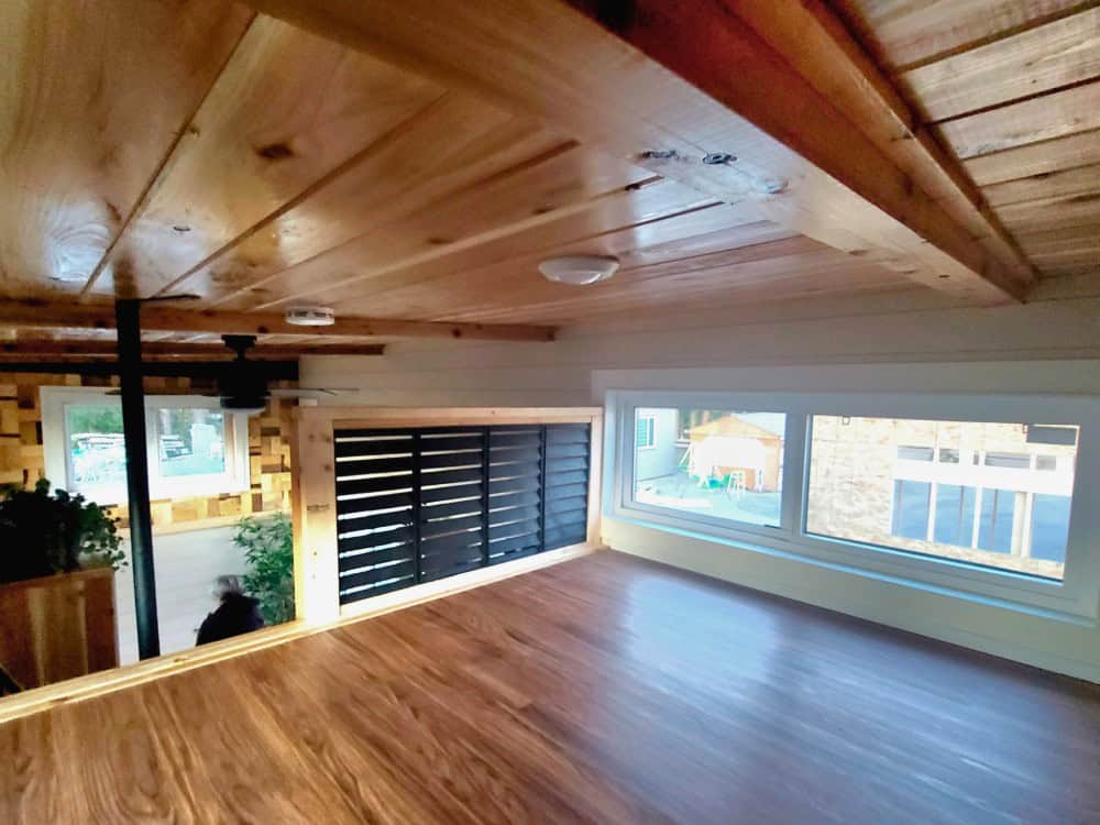 Lofted upper level of the Panda Bear with cedar-plank ceiling, reclaimed wood-tile accent wall, and large windows