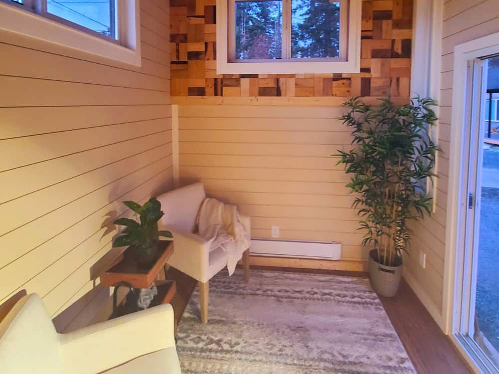 Panda Bear sitting room with shiplap walls, a reclaimed wood-tile accent wall, big windows, and a reading armchair
