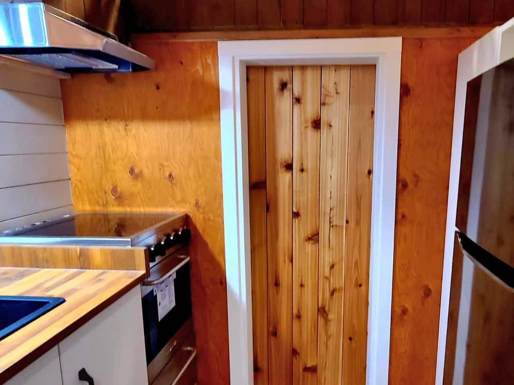 Galley kitchen of the Salmon Bear with butcher-block counters, cooktop, wall oven, range hood, and stainless refrigerator