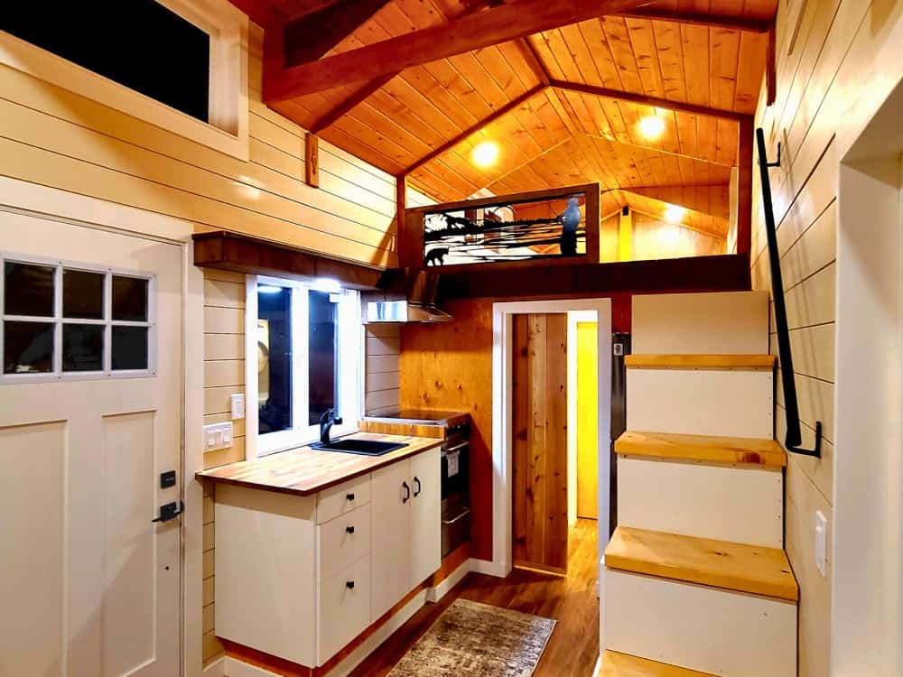 Built-in box staircase leading to the loft bedroom in the Salmon Bear tiny house, beside the kitchen
