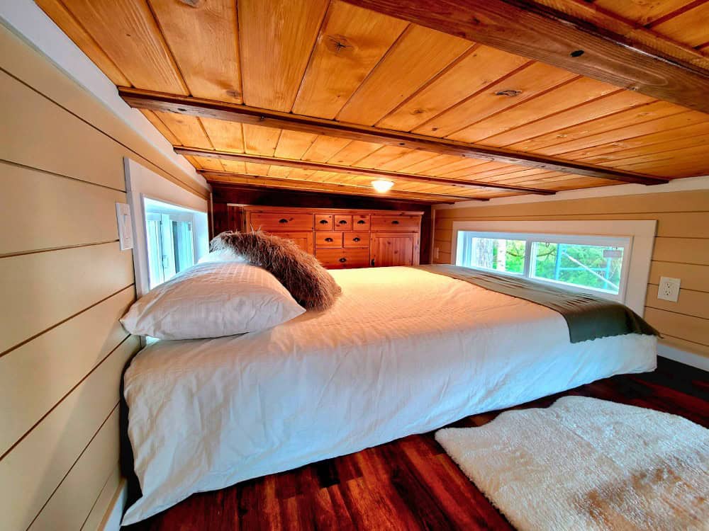 Queen loft bedroom in the Skylar Bear with a built-in dresser, cedar-plank ceiling, and windows on multiple sides