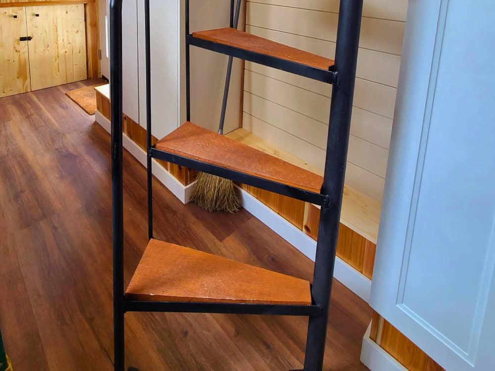 Black metal spiral staircase with wood treads in the Skylar Bear tiny house