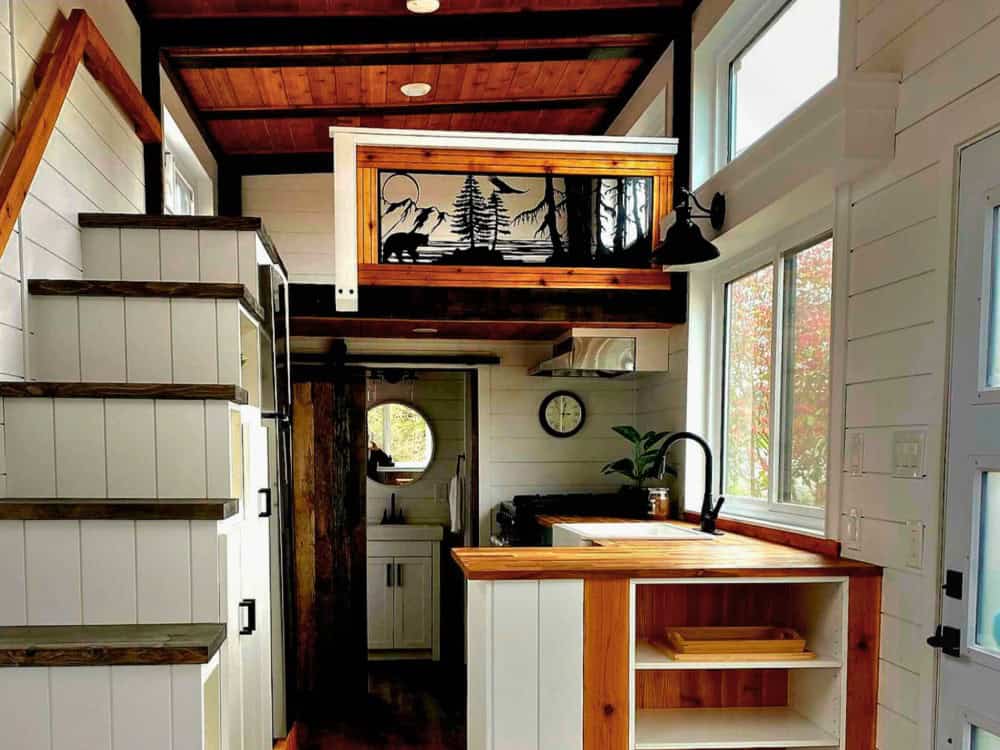 Interior of the Spirit Bear showing a built-in staircase to the loft and a custom laser-cut metal railing depicting a bear in a mountain landscape
