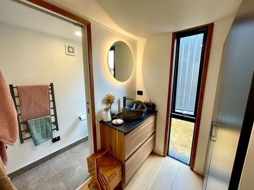 Cozy bathroom with modern sink and mirror in a compact tiny house design.
