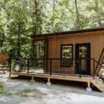 Charming tiny house in Haliburton, Ontario, featuring a modern design and cozy outdoor deck amidst l.