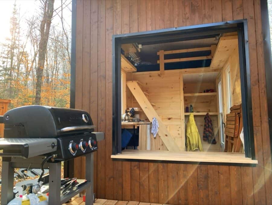 Charming tiny house with a warm wooden interior and large window in Haliburton, Ontario. Perfect for.
