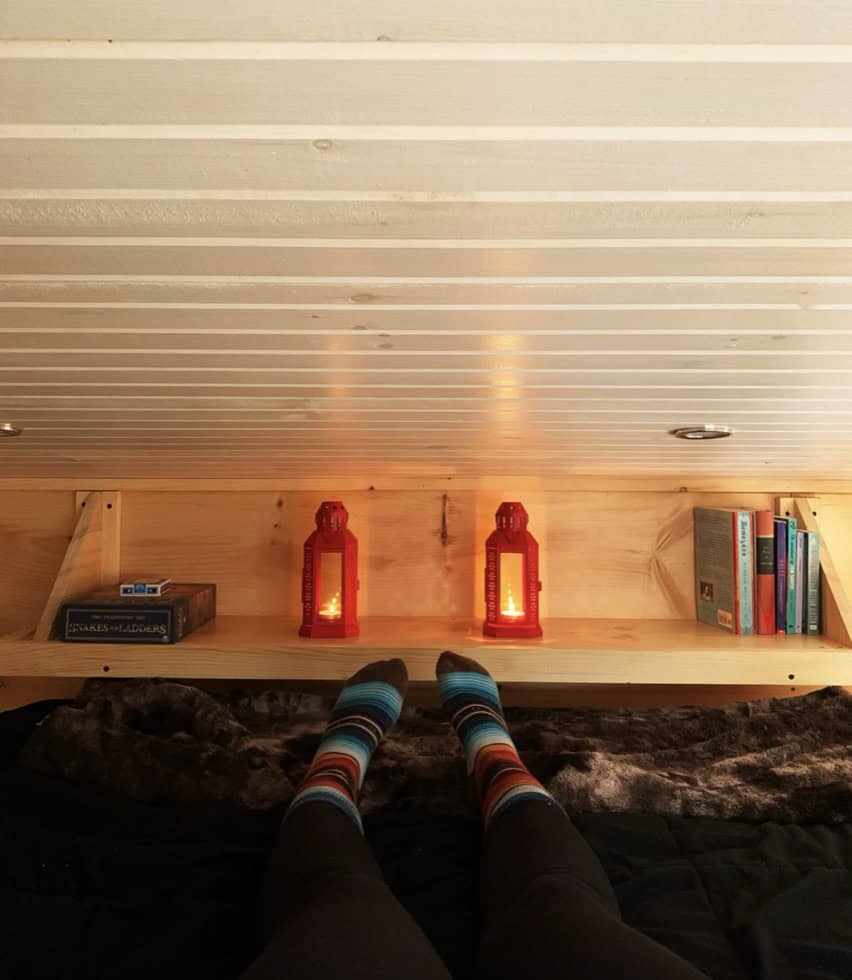 Cozy tiny house interior with colorful socks, warm lanterns, and books in Haliburton, Ontario.