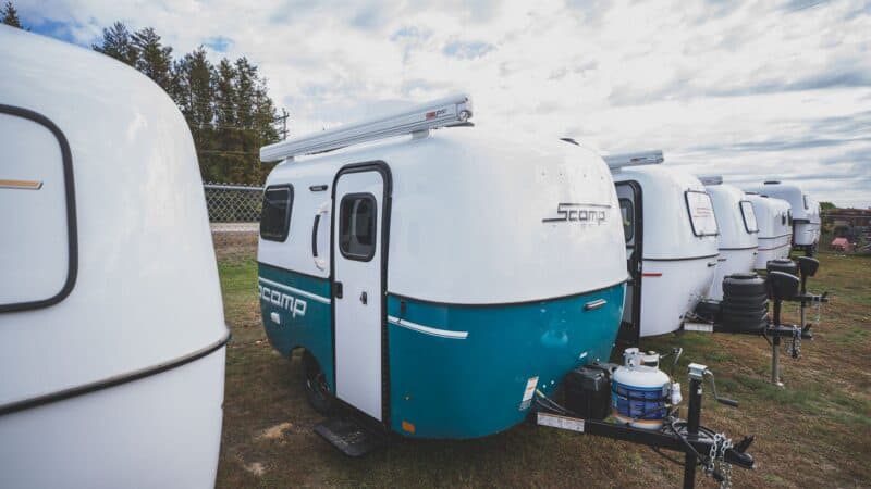 Scamp 13 with a turquoise lower shell parked in a row of trailers