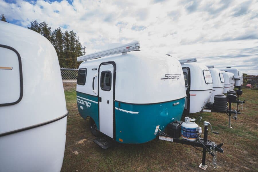 Scamp 13 with a turquoise lower shell parked in a row of trailers