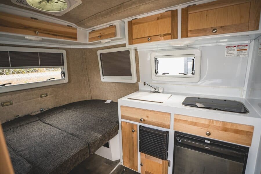 Rear bed and galley with maple cabinets and white counters
