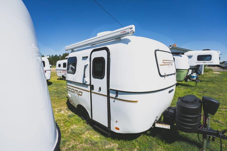 White Scamp 13 with an awning on a grassy lot