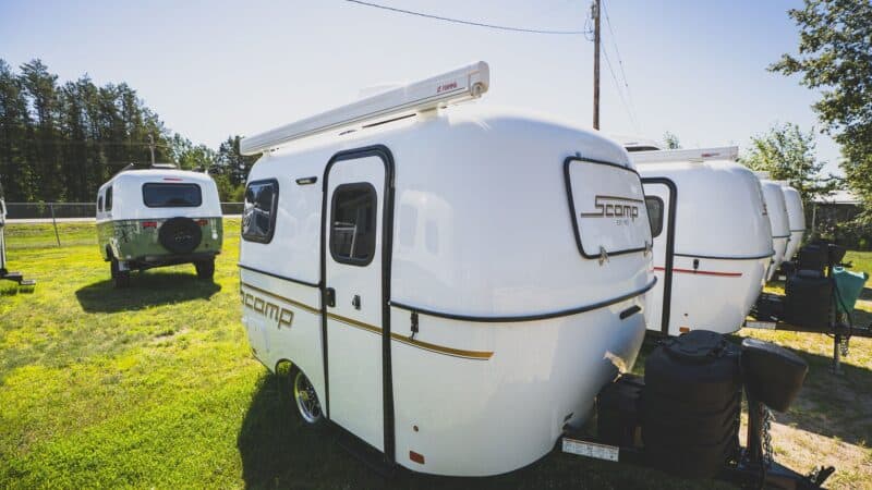 White Scamp 13 with an awning on a grassy lot