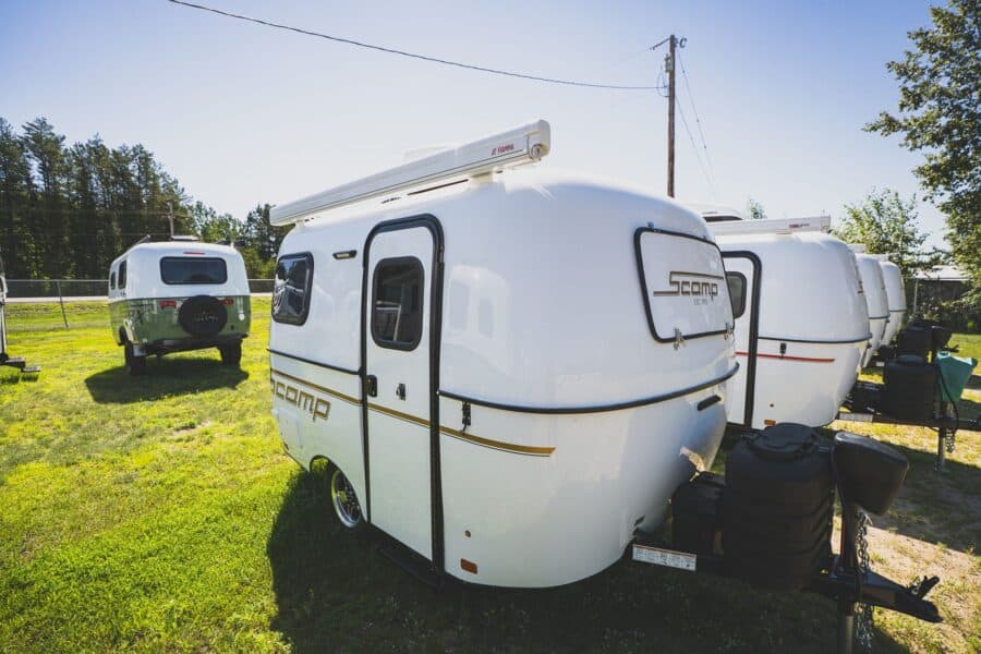 White Scamp 13 with an awning on a grassy lot