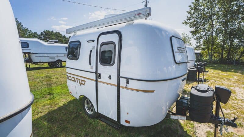 White Scamp 13 with an awning on a grassy lot